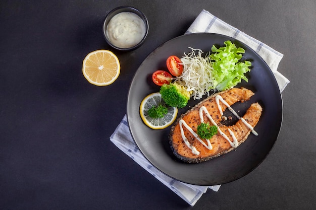 Bistecca di salmone in banda nera su sfondo nero