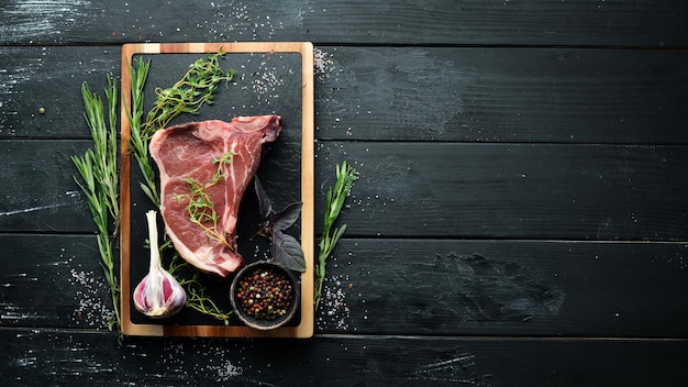 Bistecca di Tbone cruda su un tavolo di legno Vista dall'alto Spazio libero per il testo