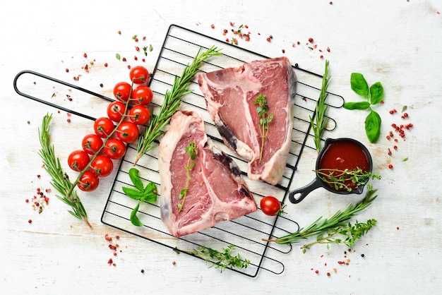 Bistecca di Tbone invecchiata cruda con rosmarino su fondo di legno bianco Vista dall'alto Stile rustico