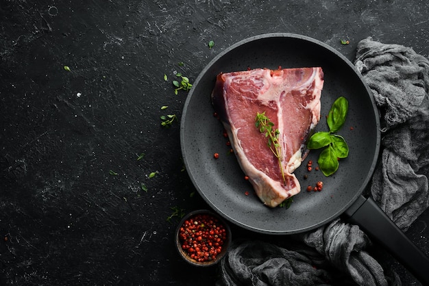 Bistecca di Tbone invecchiata cruda su sfondo di pietra nera Vista dall'alto Stile rustico