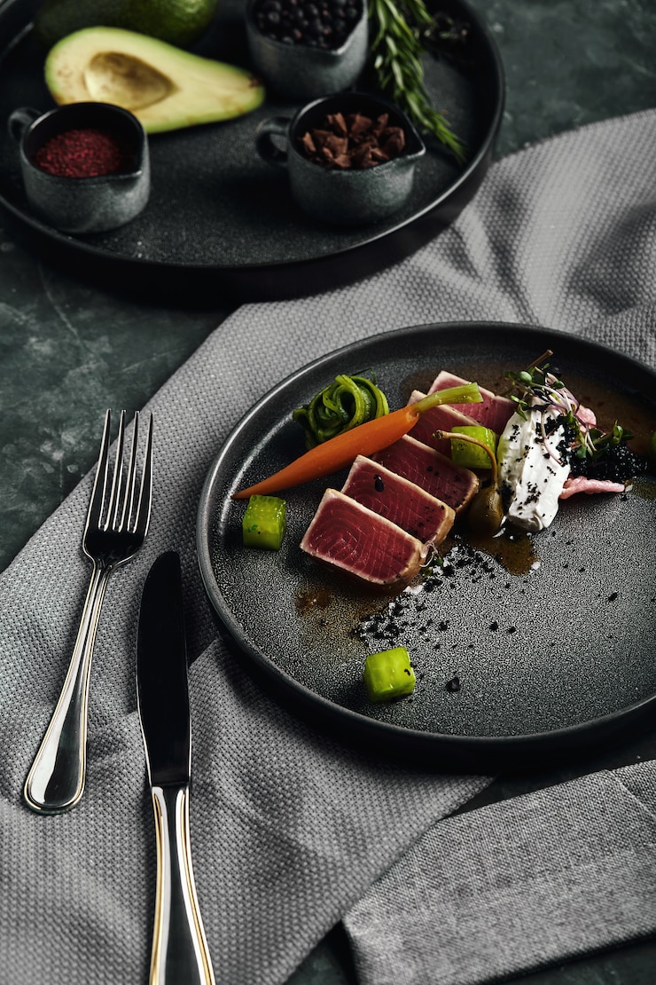 Foto bistecca di tonno con verdure su un piatto, tonno fresco affettato meravigliosamente disposto, con verdure grigliate.