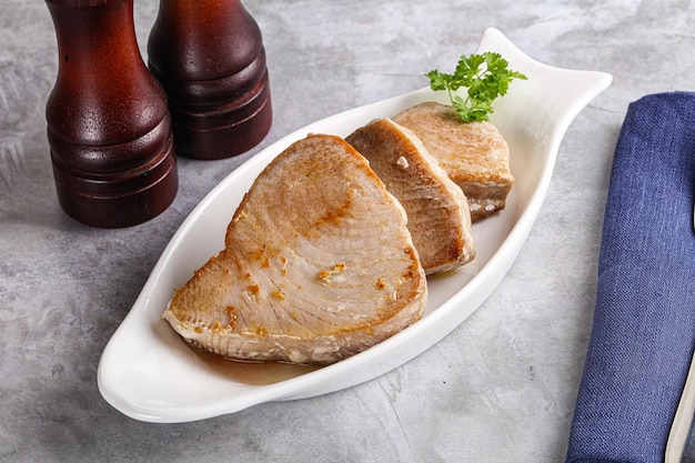 bistecca di tonno rosso arrostita nel piatto servito di prezzemolo