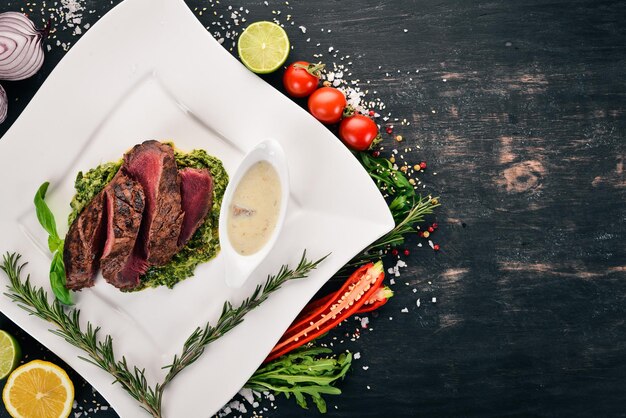 Bistecca di vitello al pepe con spinaci su sfondo di legno Vista dall'alto Spazio di copia