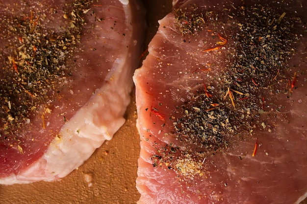 bistecca di vitello su un tagliere bistecca di vitello con spezie su un tagliere di plastica