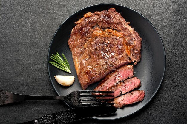 Bistecca Ribeye alla griglia mediamente rara su sfondo scuro Vista dall'alto