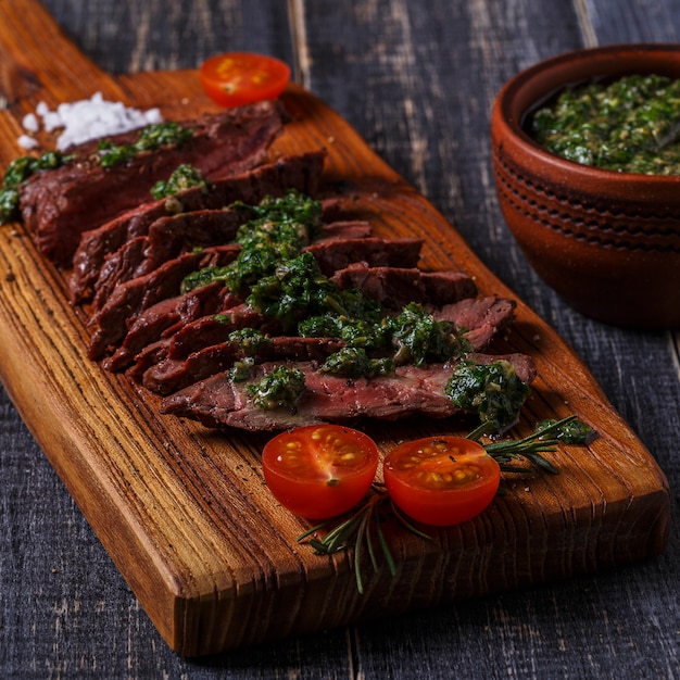 Bistecca servita su un tagliere con salsa verde