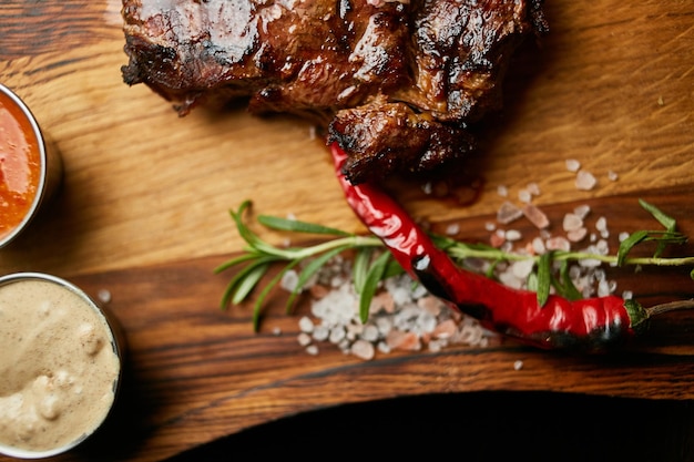 bistecca succosa su una tavola di legno con salsa pepe sale ed erbe aromatiche cotte carne succosa