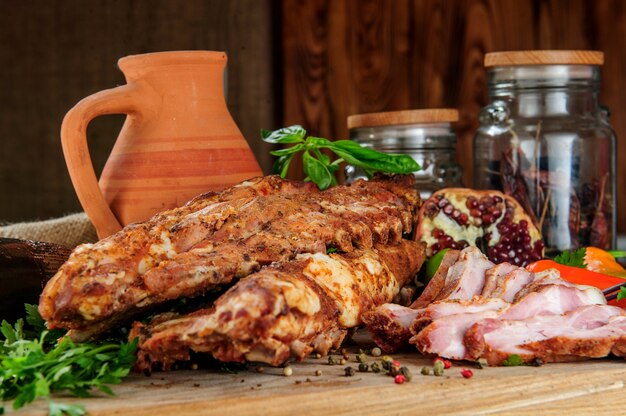 Bistecca sulle costolette, al forno e servita con peperoncino colorato. Fondo rustico in legno. Vista dall'alto.