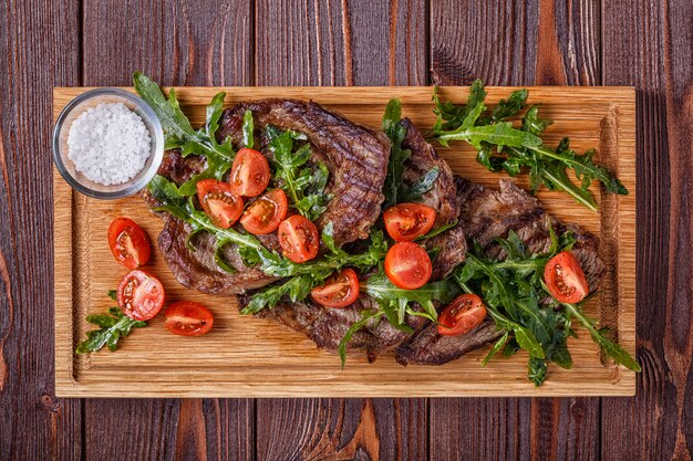 Bistecche con rucola e pomodori.