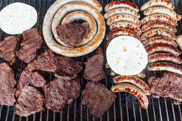 Bistecche di carne con salsicce e focaccia in cima