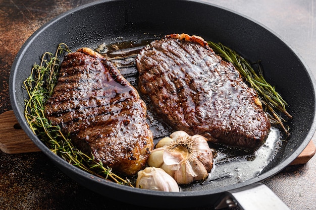 Bistecche di manzo bio picanha alla griglia in padella con erbe e aglio