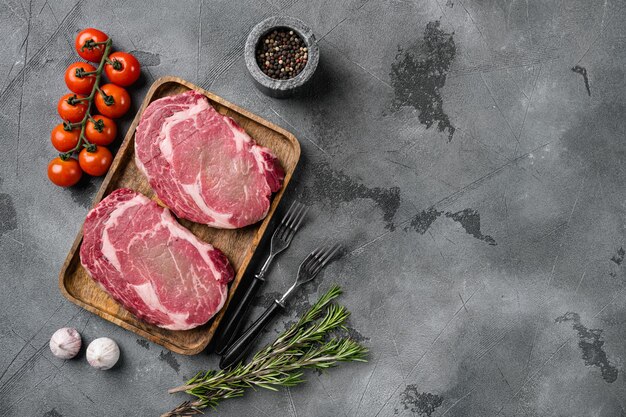 Bistecche di manzo con spezie, su sfondo grigio tavolo in pietra, vista dall'alto piatto, con spazio per la copia del testo