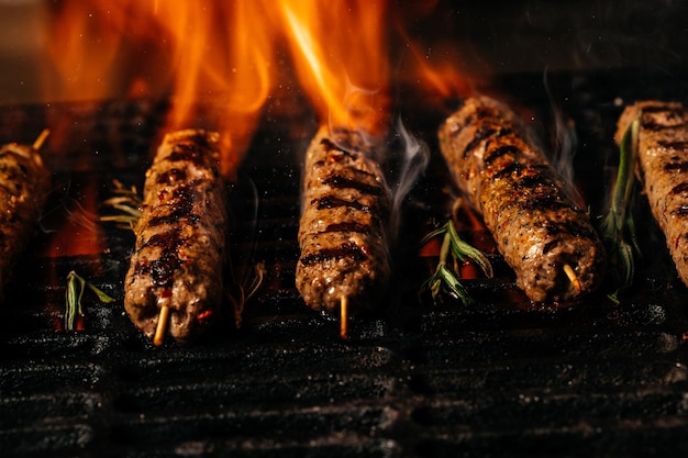 Bistecche di manzo pezzi di carne alla griglia con fiamme Cucina americana Il concetto di cottura della carne Food ricetta sfondo Primo piano posto per il testo