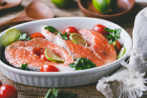 Bistecche di salmone fresco con pomodorini lime, prezzemolo e olio d'oliva Cena sana o concetto di pranzo