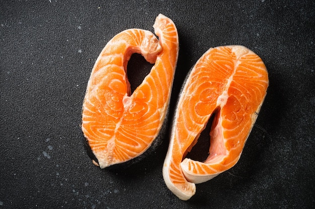 Bistecche di salmone fresco di pesce crudo su sfondo nero