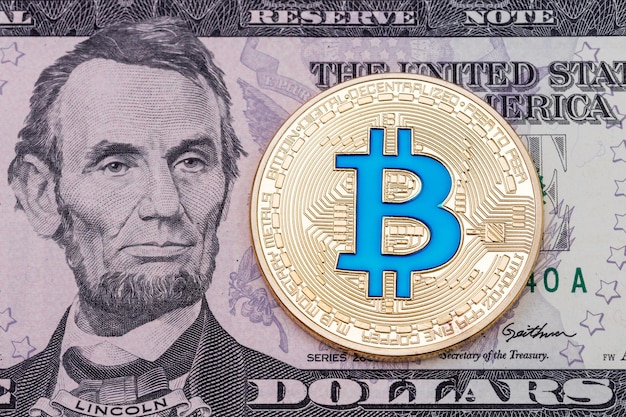 Bitcoin blu di cruptocurrency dorato su sfondo di banconote in dollari