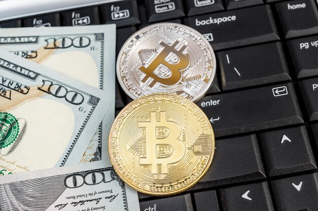 Bitcoin con banconote da un dollaro sulla tastiera del laptop