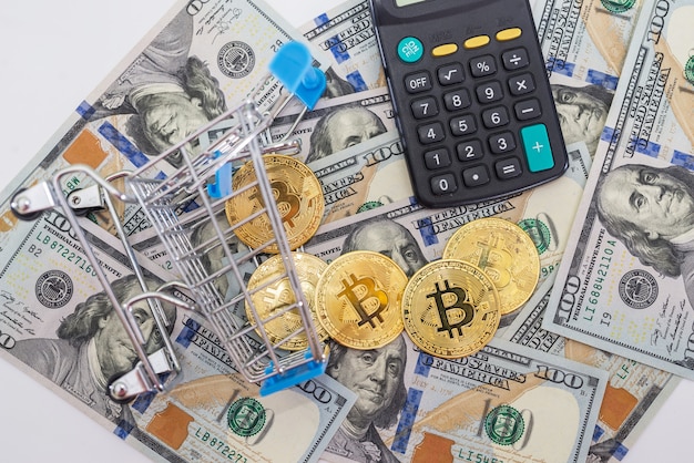 Bitcoin con calcolatrice e carrello della spesa di dollari. Concetto di acquisto di Bitcoin