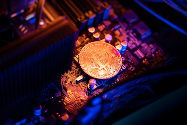 Bitcoin Cryptocurrency coin su una scheda madre del computer PC, concetto di mining di criptovaluta.