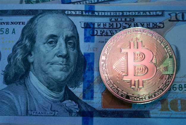 Bitcoin d'oro su banconote da cento dollari da vicino