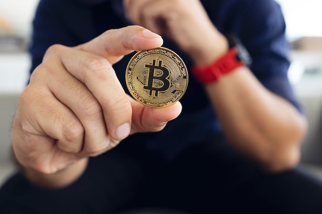 Bitcoin dorato in mano di un uomo d'affari in ufficio