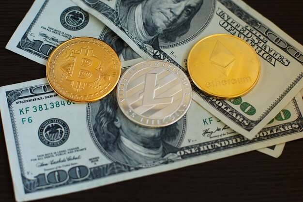 Bitcoin dorato, litecoin d'argento ed ethereum su dollari americani da vicino.