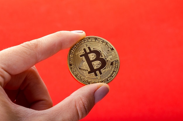 Bitcoin dorato nella mano di un uomo