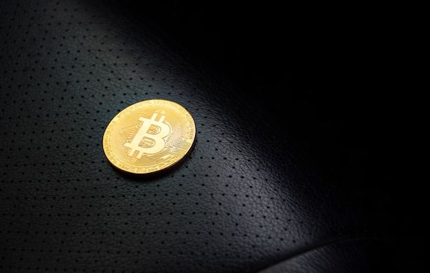 Bitcoin dorato posizionato sul sedile in pelle con spazio copia nero a destra