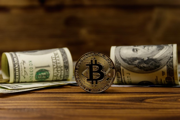 Bitcoin e dollari dorati su fondo di legno