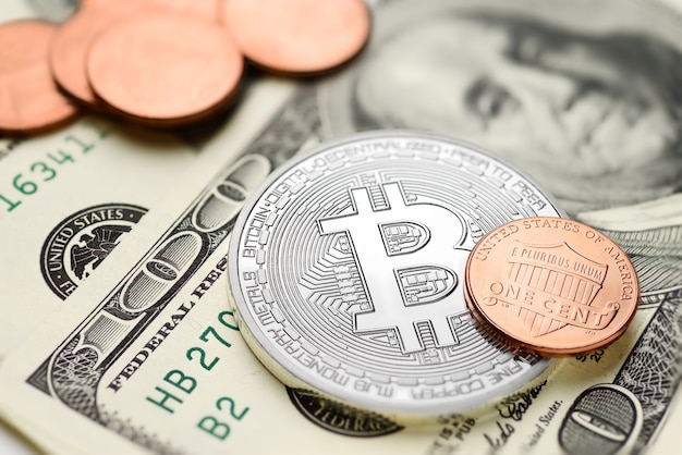 Bitcoin e monete da un centesimo sulle banconote in dollari USA. Concetto di scambio di denaro elettronico