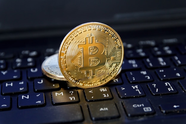 Bitcoin è posto sulla tastiera del laptop, concetto di tecnologia di trading di criptovaluta.