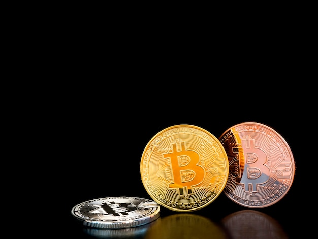 Bitcoin in oro, argento e bronzo su sfondo nero