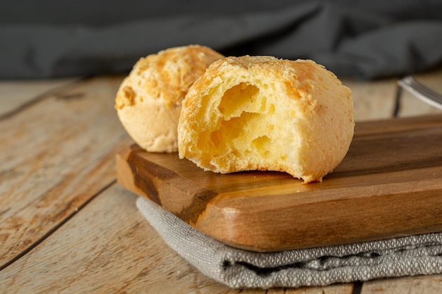 bitten pão de queijo (o pane al formaggio in inglese) su un tavolo di legno