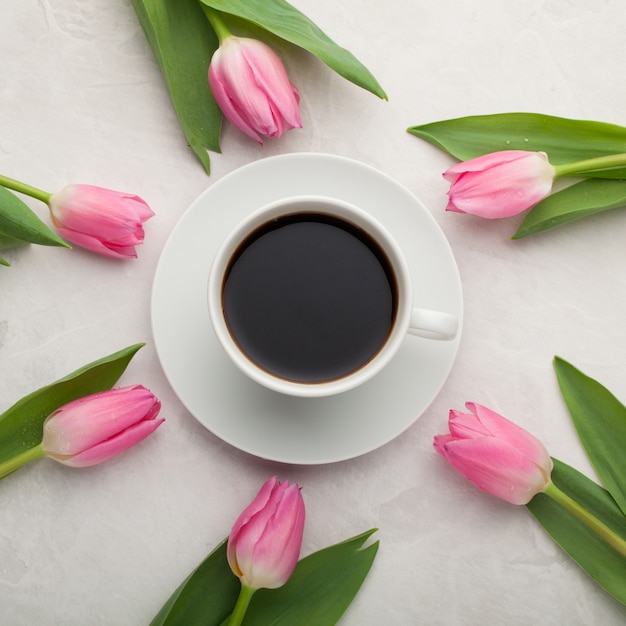 Black coffee in white Cup and tulips.