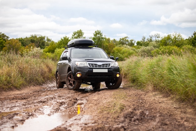 Black Subaru Forester alla strada forestale sporca in estate