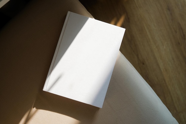 blank book mockup on soft armchair shadow overlay