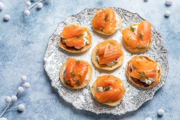 Blini con salmone affumicato e panna acida, guarnito con aneto