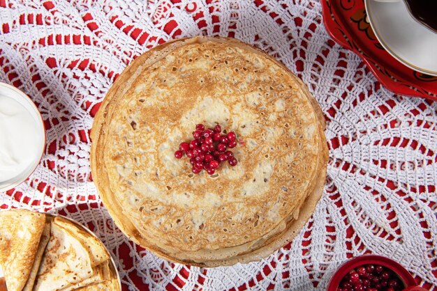 Blini russo di pancake con frutti di bosco e panna acida sul tavolo shrovetide maslenitsa festival concep...