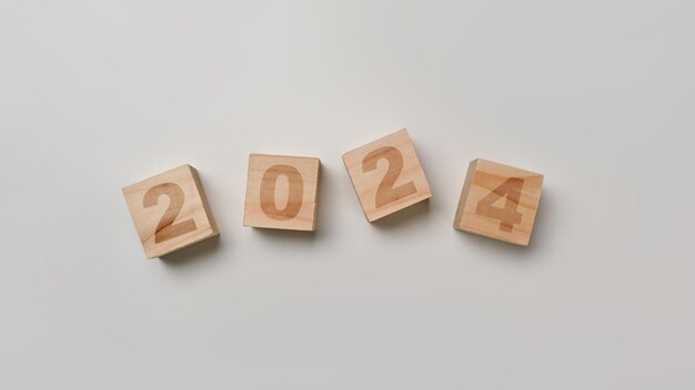 Blocchi di cubo di legno con testo per il 2024 su sfondo bianco Obiettivi e piani di visione aziendale per il nuovo anno