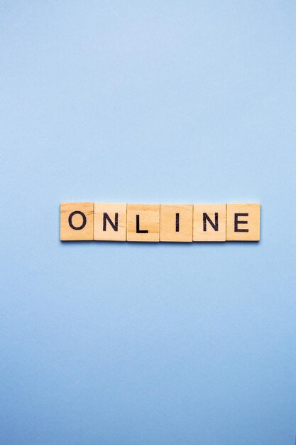 Blocchi di legno che scrivono la parola ONLINE su uno sfondo blu chiaro