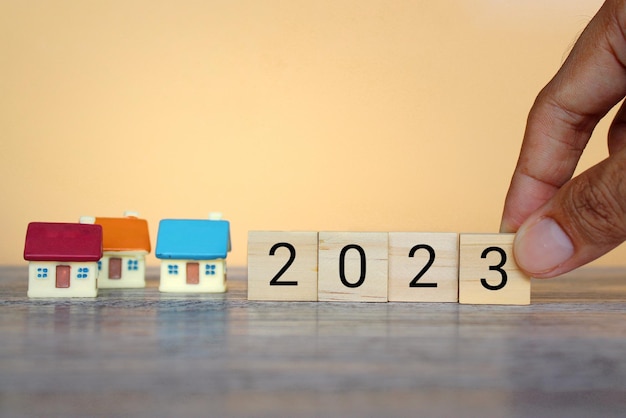Blocchi di legno con numero 2023 e casa Previsione dell'andamento e dei cambiamenti dei prezzi degli immobili