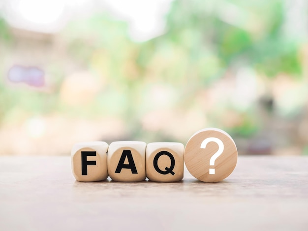 Blocco di legno con la parola FAQ con punti interrogativi Il concetto di tempo di domanda o risposta