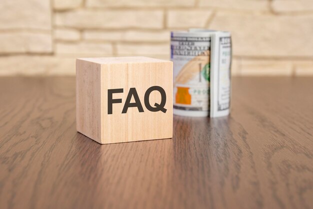 Blocco di legno con testo FAQ su sfondo scuro concetto di domande frequenti