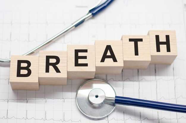 Blocco di legno forma la parola respiro con stetoscopio sul desktop del medico. concetto medico. Concettuale di assistenza sanitaria per ospedali, cliniche e attività mediche.