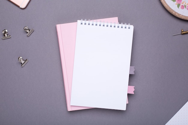 Blocco note bianco con libro rosa su grigio in stile vintage