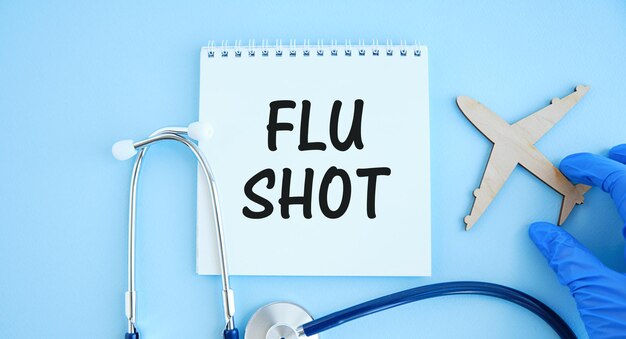 Blocco note con testo FLU SHOT, calcolatrice e stetoscopio. concetto medico.