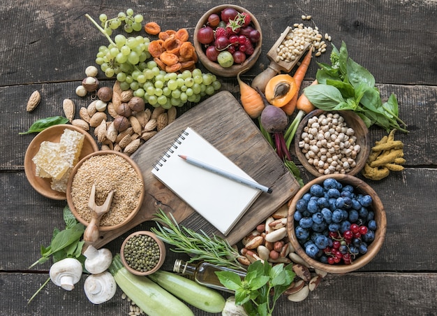 Blocco note vuoto per copia spazio e ingredienti alimentari sul tavolo di legno