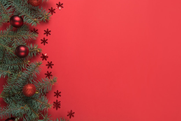 Blocco per grafici di natale con le filiali e le sfere dell'abete su priorità bassa rossa. Biglietto d'auguri. Felice anno nuovo.