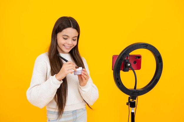 Blog di bellezza che presenta polvere e pennello per cosmetici per il trucco Ragazza teenager che parla davanti alla telecamera