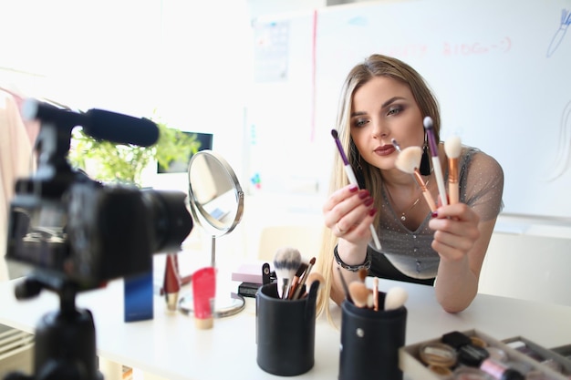 Blogger di bellezza gira video di routine di trucco delle donne quotidiane sulla fotocamera